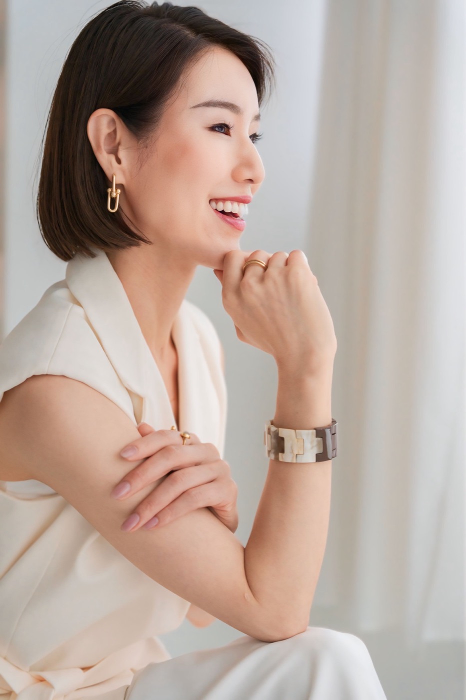 白い服で柔らかく微笑む藤井知子の横顔